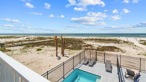 A pool area with lounge chairs and a view of the beach and ocean. - Salty Sisters (Port St. Joe)