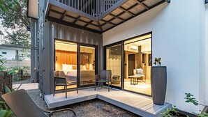 A modern outdoor patio with a seating area, a large potted plant, and a view into the interior of the building. - Z102 studios (Potrero)
