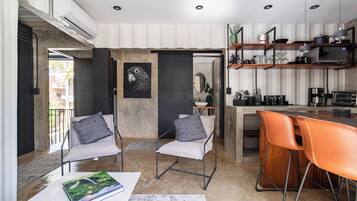Una cocina moderna con barra, dos sillas y una mesa de comedor.