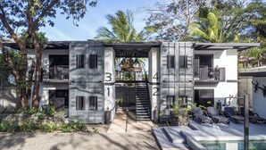 A modern building with a pool, numbered balconies, and outdoor seating. - Z102 studios (Potrero)
