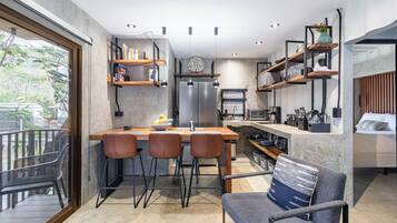 Una cocina moderna con una isla central, taburetes de bar y estantes empotrados.