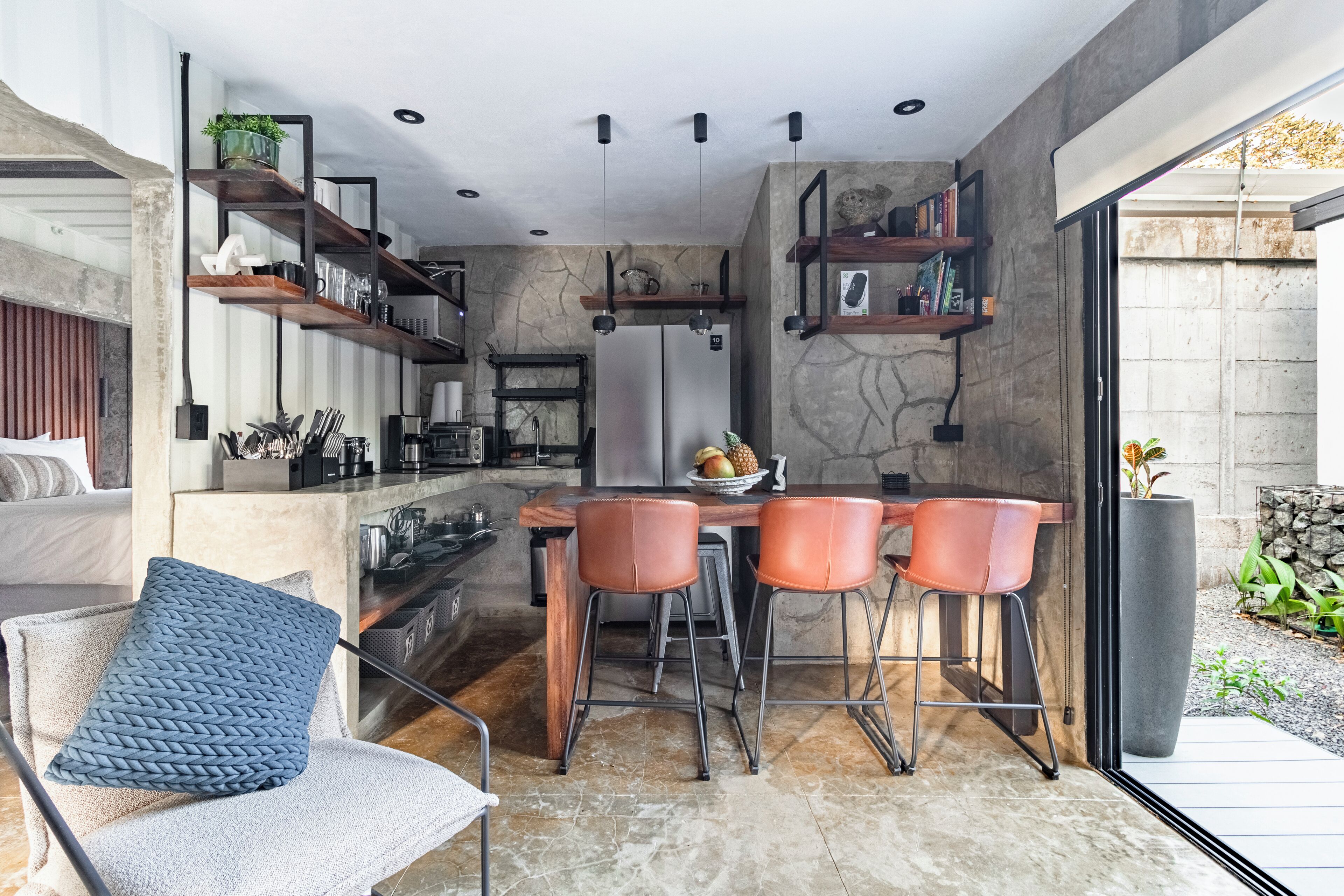 Una cocina moderna con una isla central, taburetes de bar y un comedor.