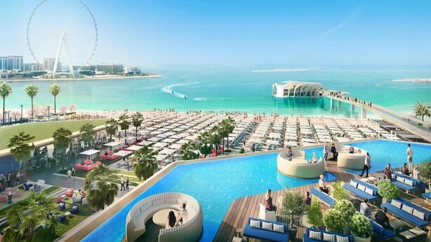 Ein Resort mit großem Pool, einem Riesenrad und einem Strandbereich.