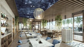 Eine moderne Bar mit Korbmöbeln, einer Marmorplatte und hängenden, kugelförmigen Leuchten.
