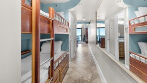 A corridor with bunk beds, a hallway with a mirror, and a door leading to a bathroom. - Sundestin 711 (Destin)