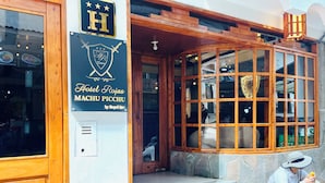 A hotel entrance with a sign reading "Hotel Rojas MACHU PICCHU by Royal Inti". - Hotel Rojas Machupicchu (Aguas Calientes)
