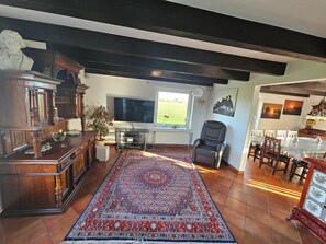 Relax in this traditional living room with a large cabinet, comfortable armchair, and vibrant rug.
