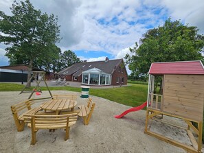 Children can play on the swing set, slide, and at the picnic table in this outdoor play area.