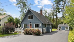 A two-story house with a front porch, a chimney, and a small attached garage.