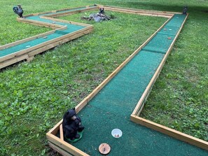Un campo de mini golf con marcos de madera y césped verde.