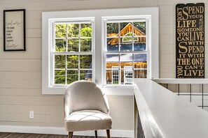 A room with a large window, a chair, and a wall with a motivational quote. - Renovated Post Office w/Waterfall & Mini Golf (Cosby)