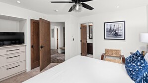 A bedroom with a bed, a television, a ceiling fan, and a framed picture on the wall. - Crestwood 1201 Premier 3 Bedroom (Snowmass Village)