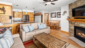 A modern kitchen with wooden cabinets, a stainless steel refrigerator, and pendant lights. - Crestwood 1202 Deluxe 3 Bedroom (Snowmass Village)