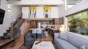 Ein modernes Interieur mit Treppe, einer Couch, einem Couchtisch und einer Küchenzeile.