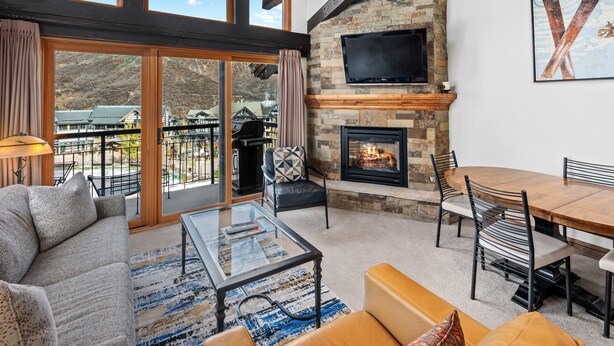 A spacious living area with a fireplace, a dining table, and a sofa.