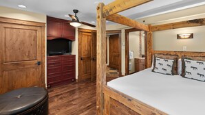 Un dormitorio con una cama baldaquín de madera, un televisor y un ventilador de techo.