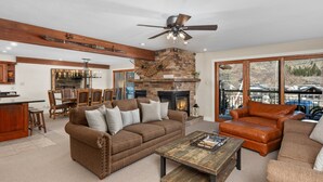 A spacious living room with a fireplace, a dining area, and a kitchen. - Crestwood 2116 Premier 3 Bedroom (Snowmass Village)