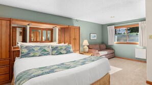 A bedroom with a large bed, wooden wardrobe, and a window with curtains. - Crestwood 2101 Deluxe 2 Bedroom (Snowmass Village)