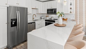 A modern kitchen with white cabinets, stainless steel appliances, and a marble countertop. - Crestwood 2202 Premier 2 Bedroom (Snowmass Village)
