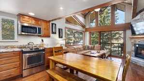 A spacious kitchen with wooden cabinets, a stainless steel oven, and a large dining table.