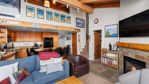 A spacious living area with a fireplace, a dining area, and a kitchen.