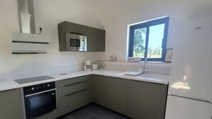 Eine moderne Küche mit Einbauofen, Mikrowelle und großem Fenster für natürliches Licht.