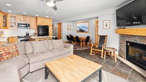 A modern living room with a sectional sofa, a wooden coffee table, and a fireplace.