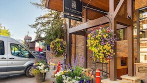 Zona de recepción de huéspedes en el Hotel Crestwood, con arreglos florales colgantes y una furgoneta estacionada.
