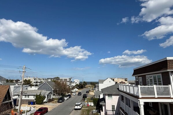 Eine Wohnstraße mit Häusern, Autos und blauem Himmel.