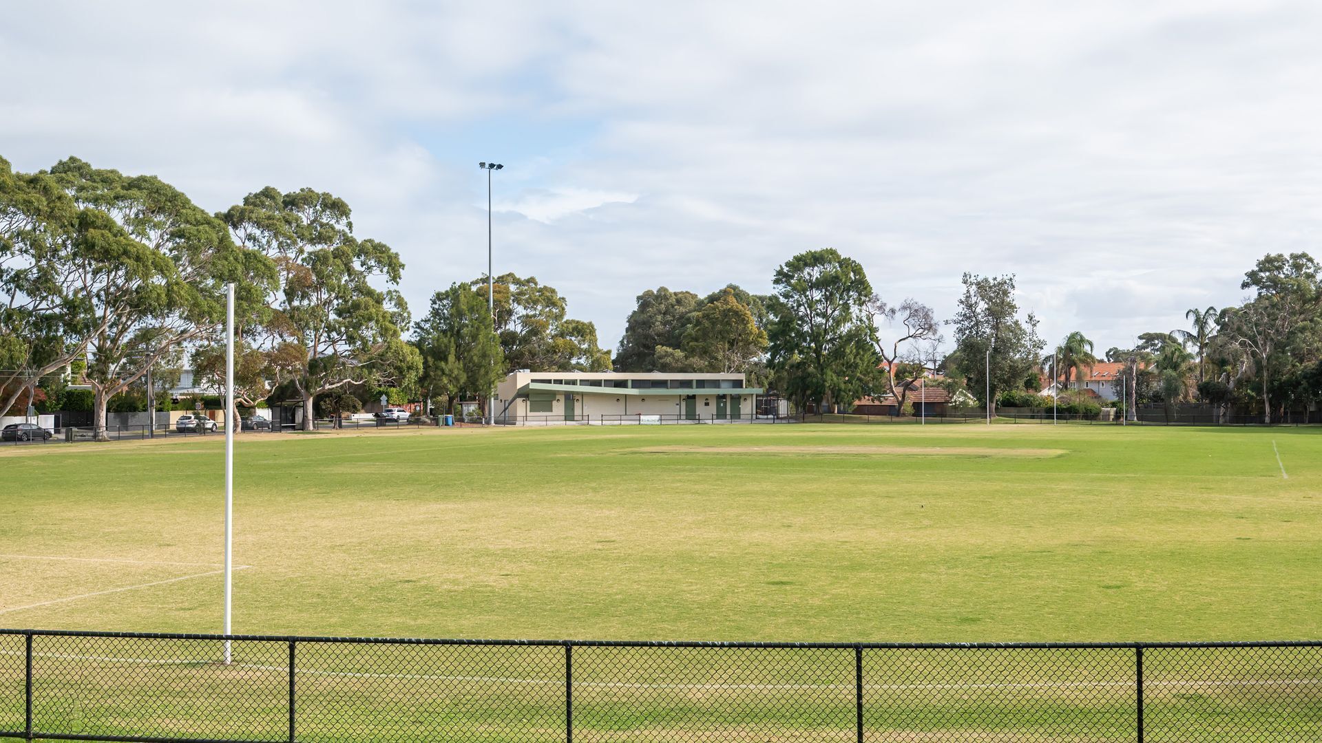 Un campo deportivo cubierto de césped con un edificio al fondo.