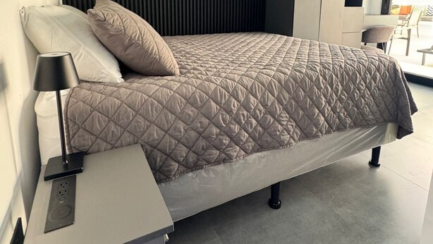 A modern bedroom with a bed, bedside table, and built-in shelving. - Ocean Dream Apartments E2-A3 (San Juan del Sur)