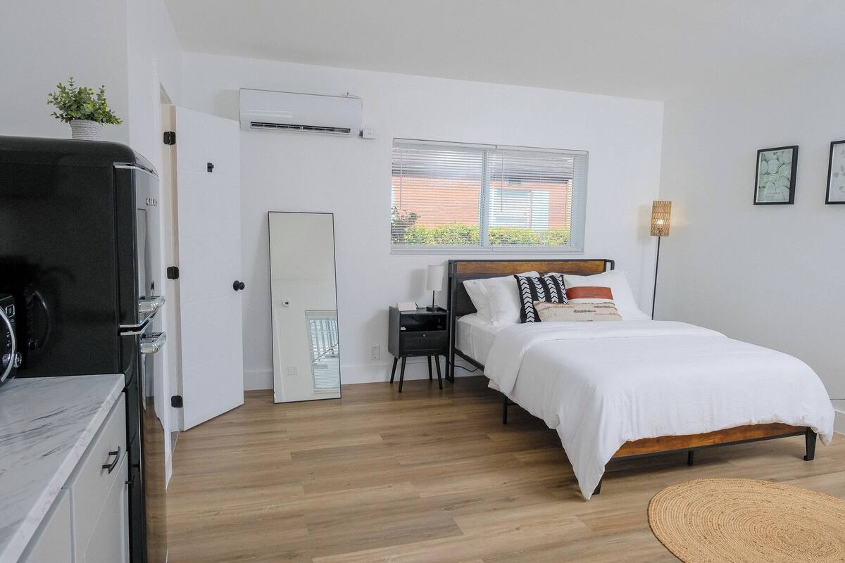 Ein Schlafzimmer mit Bett, Nachttisch und Fenster.