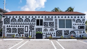 Un edificio con techo rojo y paredes blancas decoradas con patrones geométricos negros.