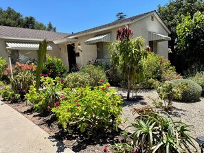 Un edificio residenziale con un giardino curato, una struttura a due piani con tetto in tegole e un numero civico ben visibile.