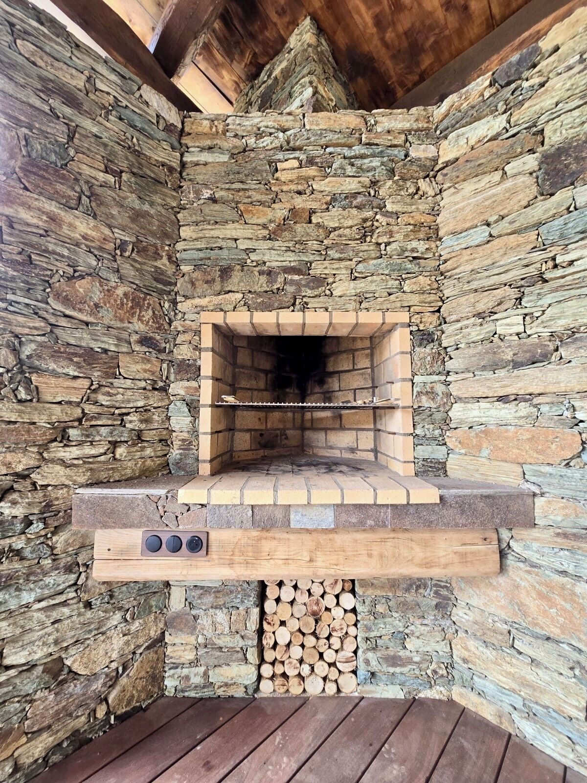 Ein Kamin aus Stein mit Backsteinverkleidung und einem Holzofen.