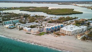 An aerial view of a coastal hotel with multiple buildings, a beachfront, and surrounding water bodies. - Beachfront Condo w/ Balcony on Manasota Key (Englewood)