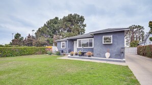 A residential house with a well-maintained lawn, a patio with outdoor furniture, and a large tree in the background. - 8 Mi to Dtwn: Home w/ Fireplace & Games in LA! (Los Angeles)