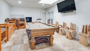 A pool table with a billiards setup, wooden chairs, a television, and a door leading to another room. - 8 Mi to Dtwn: Home w/ Fireplace & Games in LA! (Los Angeles)