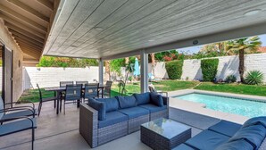 An outdoor patio with a pool, wicker furniture, and a covered seating area. - Game Room, Hot Tub & Mtn Views: Palm Springs Gem (Palm Springs)