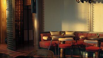 A modern interior with a seating area featuring red upholstered chairs and a round table.