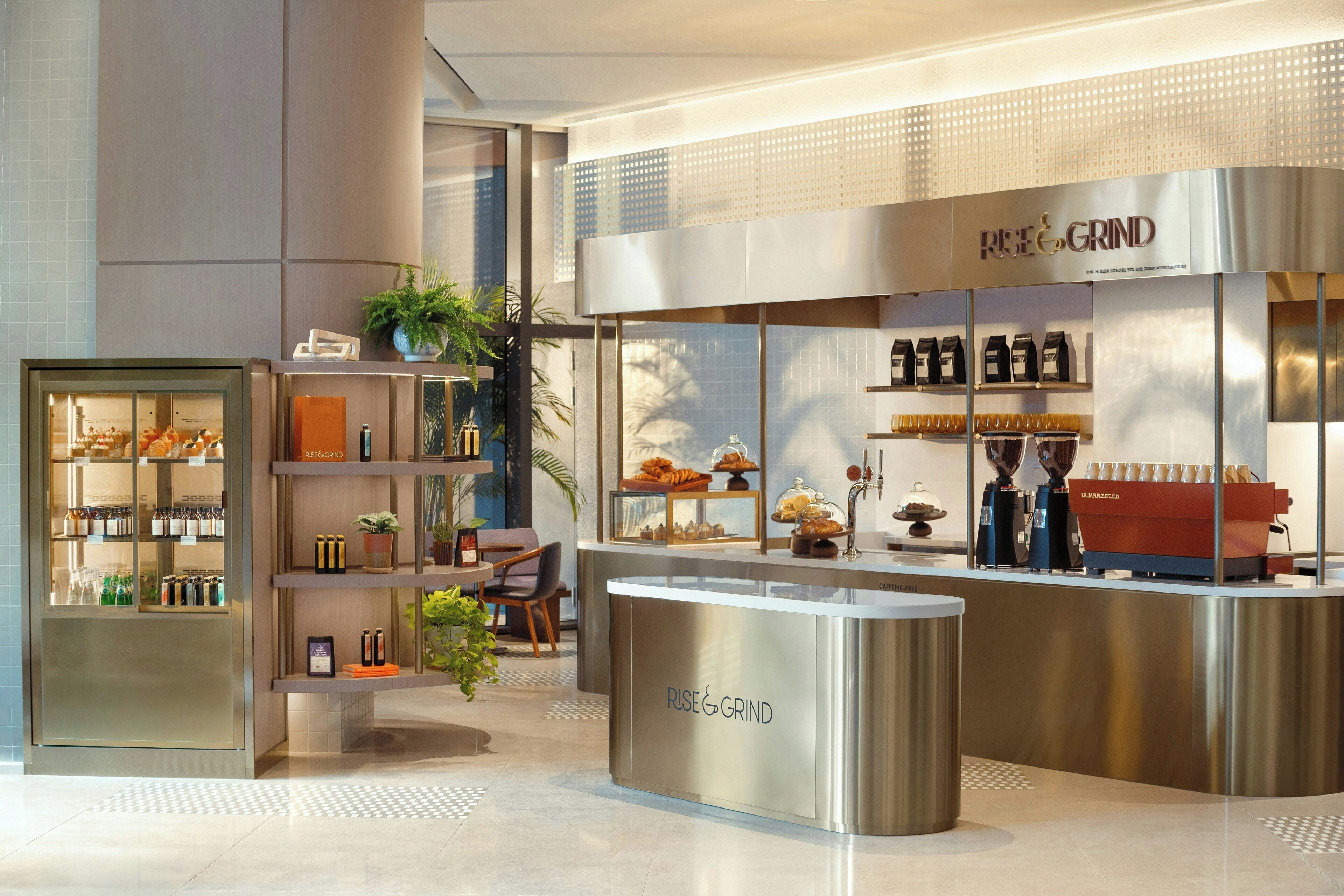 A modern coffee shop interior with a coffee machine, shelves with coffee products, and a seating area.