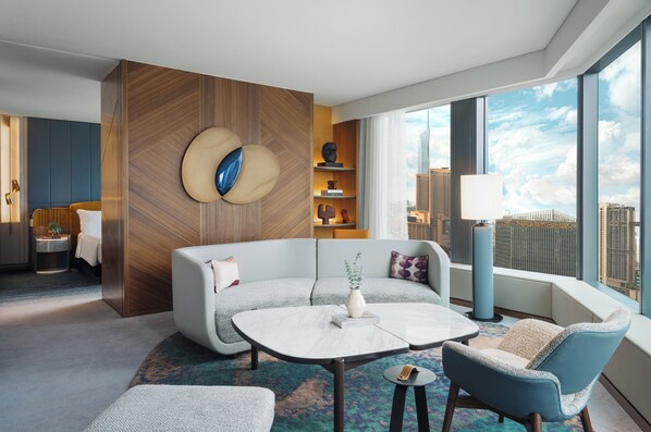 A modern hotel room with a large window, a sofa, a coffee table, and a small side table. - Kimpton Naluria Kuala Lumpur by IHG (Kuala Lumpur)