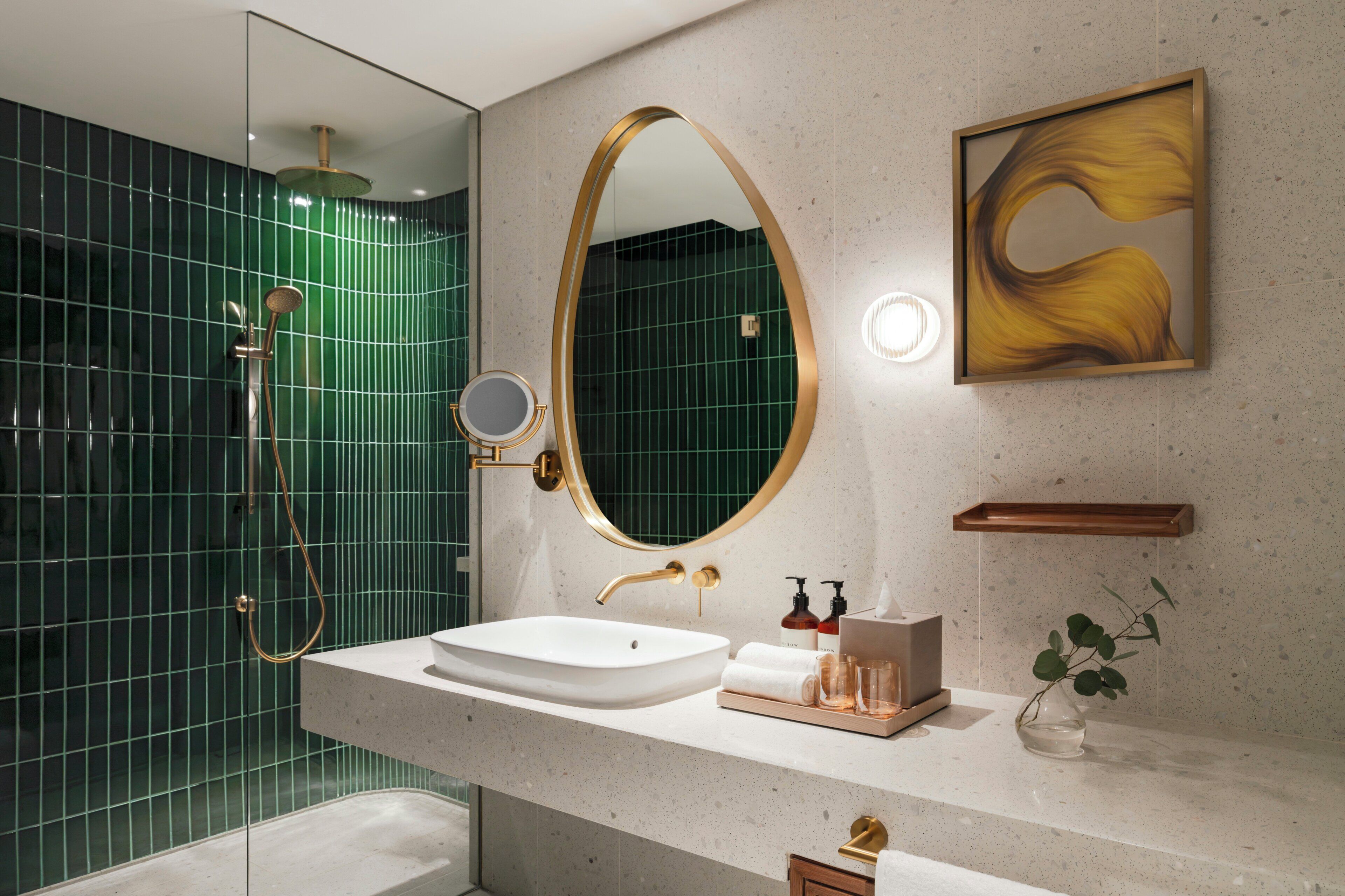 A modern bathroom with a freestanding bathtub, a large oval mirror, and a minimalist vanity.
