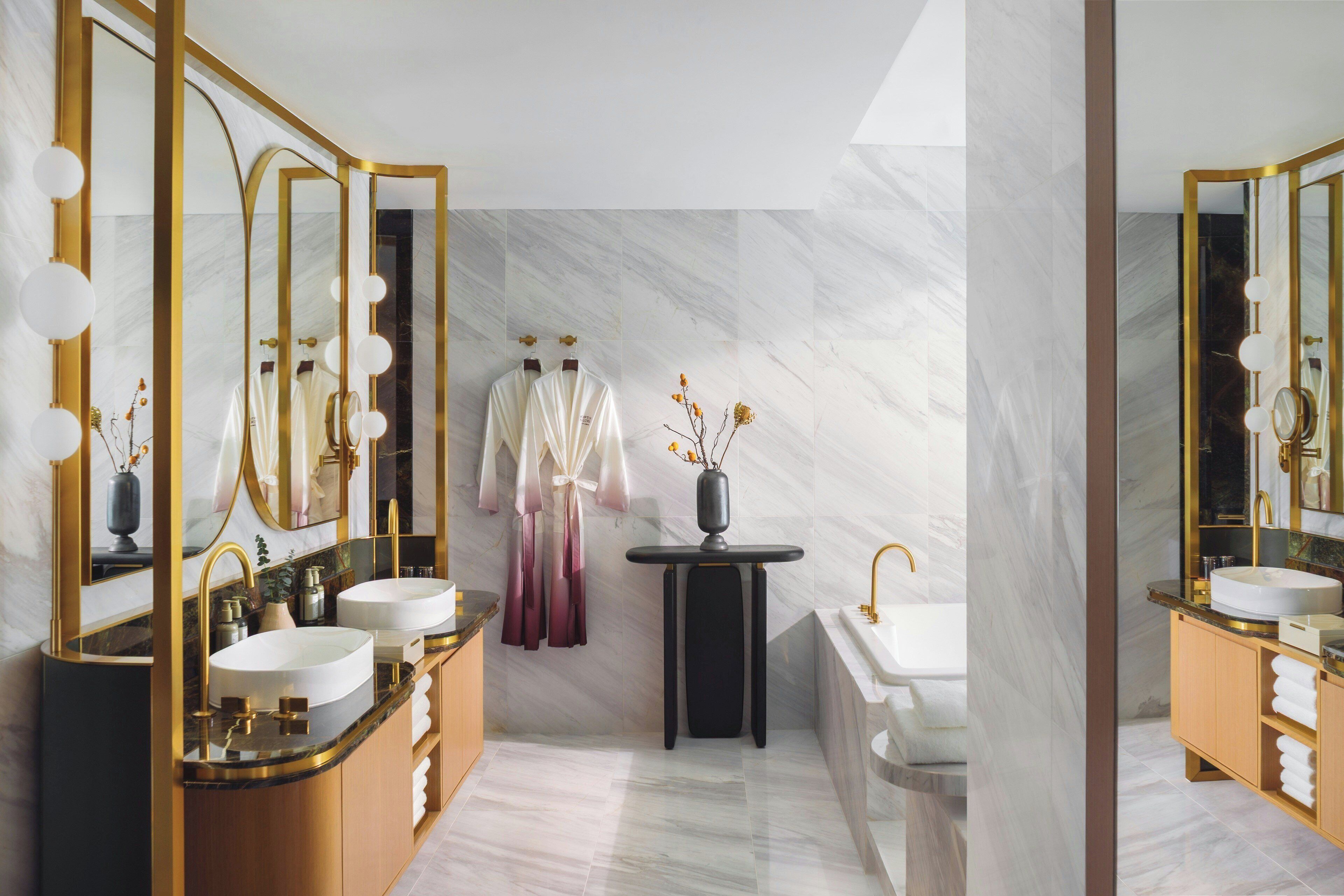 A modern bathroom with two sinks, a vanity, and a mirror.