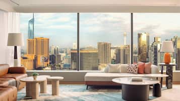 Un moderno salón con vista a la ciudad, que incluye un sofá, una mesa de centro y una lámpara.