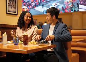 Un coin repas avec une table dressée pour deux personnes, comprenant un repas et des boissons.