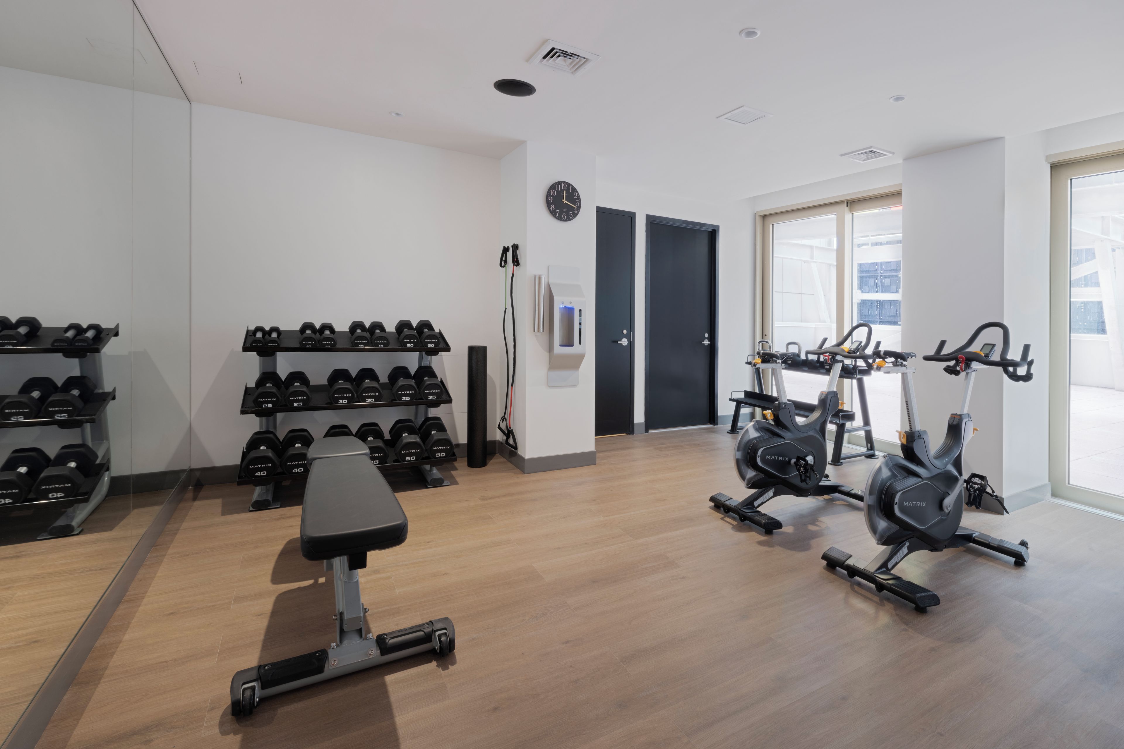 A gym with exercise equipment, weight racks, and a bench.