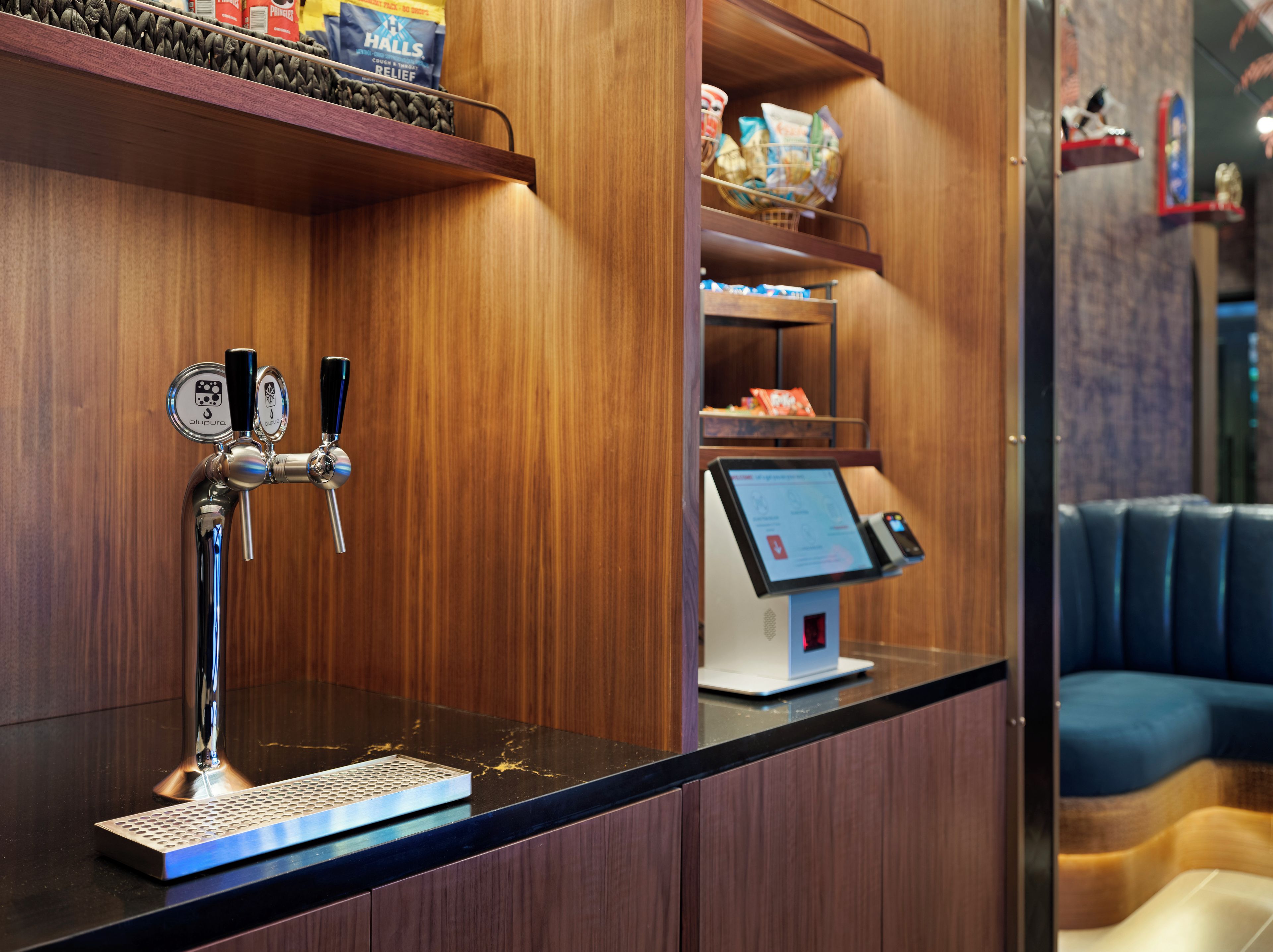 Una zona de bar con una grifería y una estación de pedidos digitales.