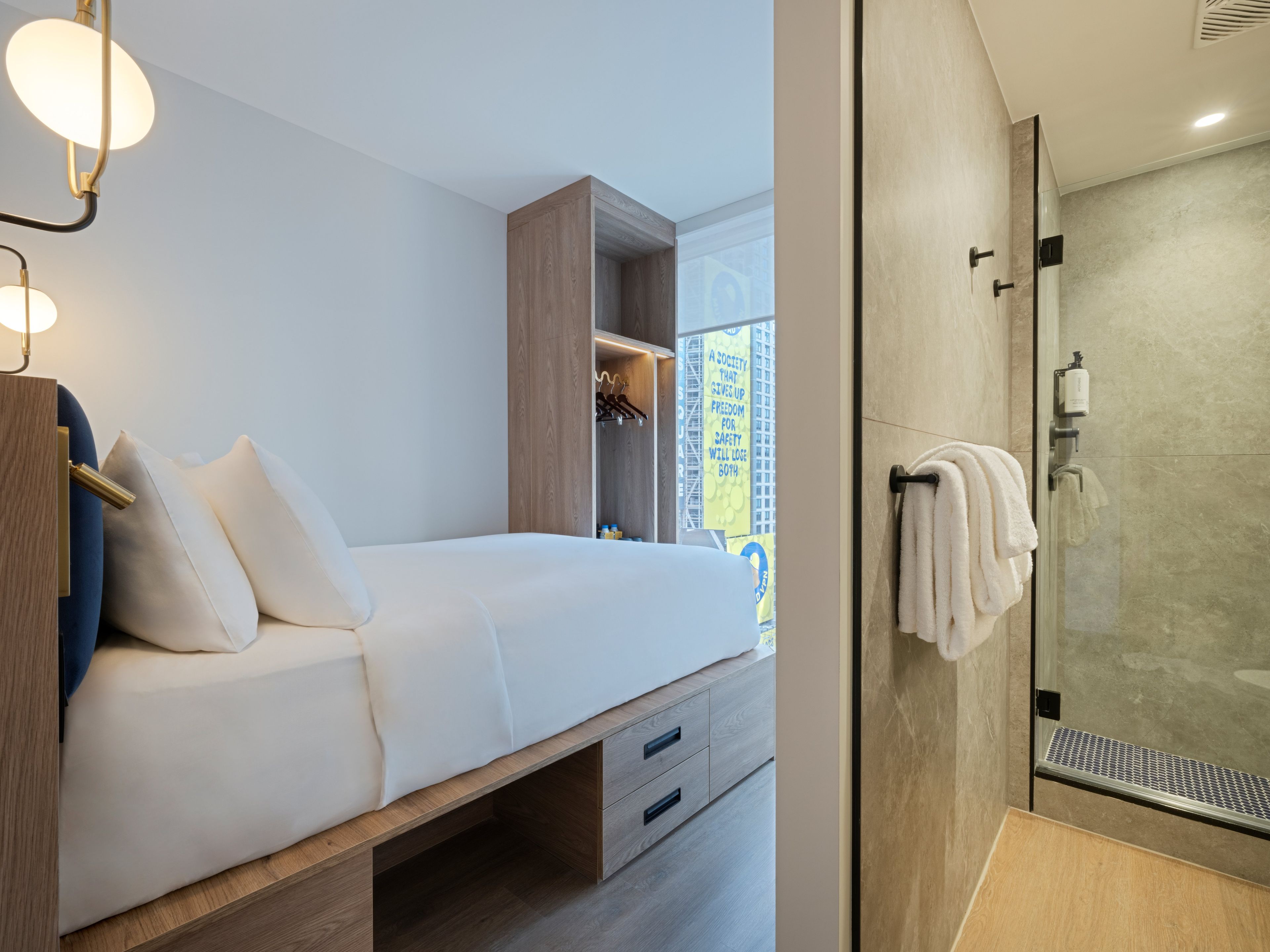 A modern bedroom with a bed, bedside table, and a walk-in closet.