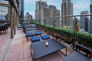 A rooftop terrace with outdoor seating and a city view.